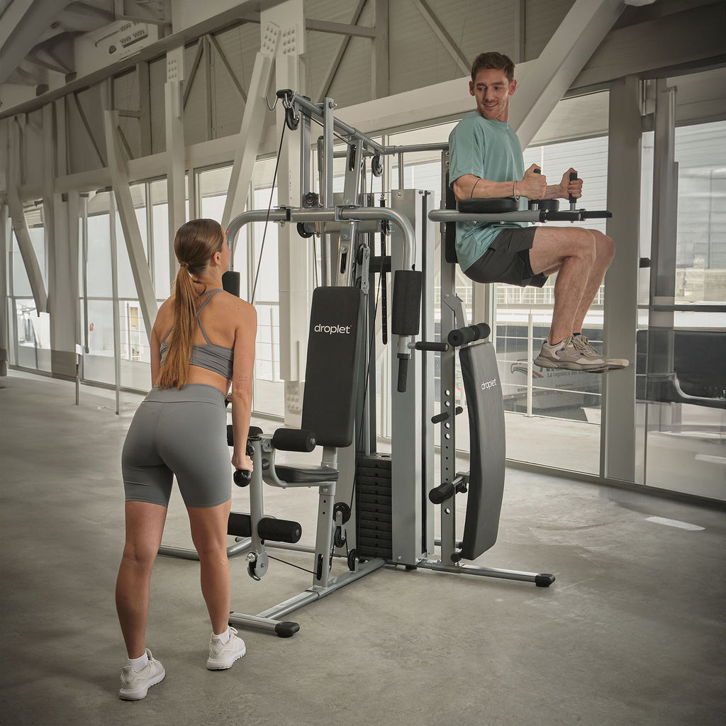 Imagen ambientada de gym en casa con dos personas usando estaciones distintas.